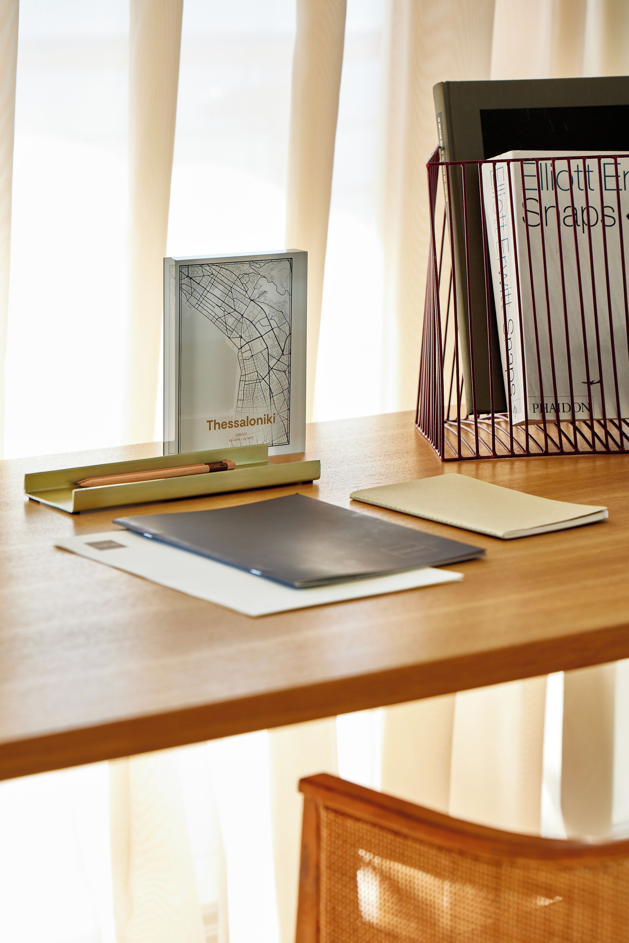 Een houten bureau met een kaart, een notitieboek en een pen.