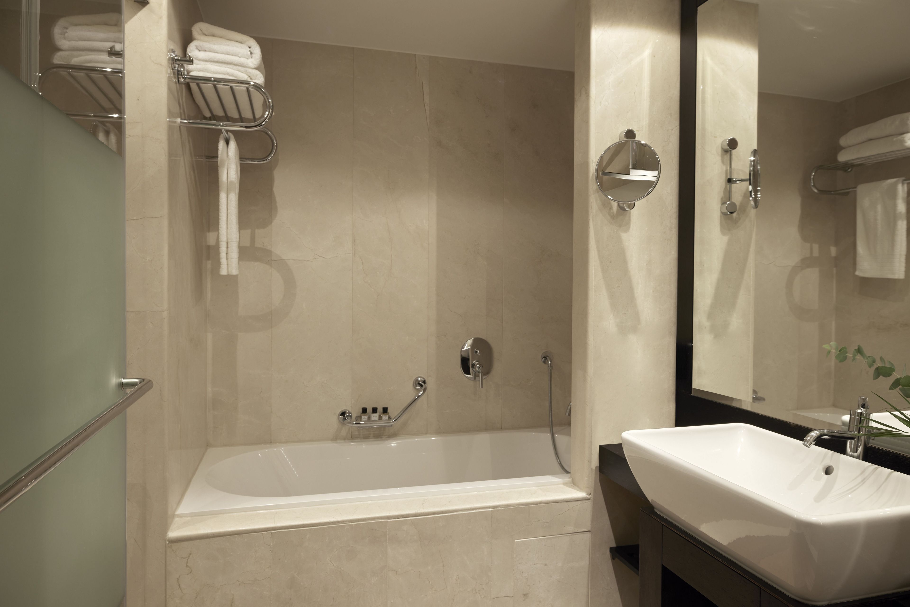 A modern bathroom with a bathtub, a sink, and a shower area.
