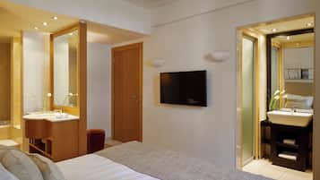A modern bedroom with a bed, two bedside tables, a TV, and a large mirror.