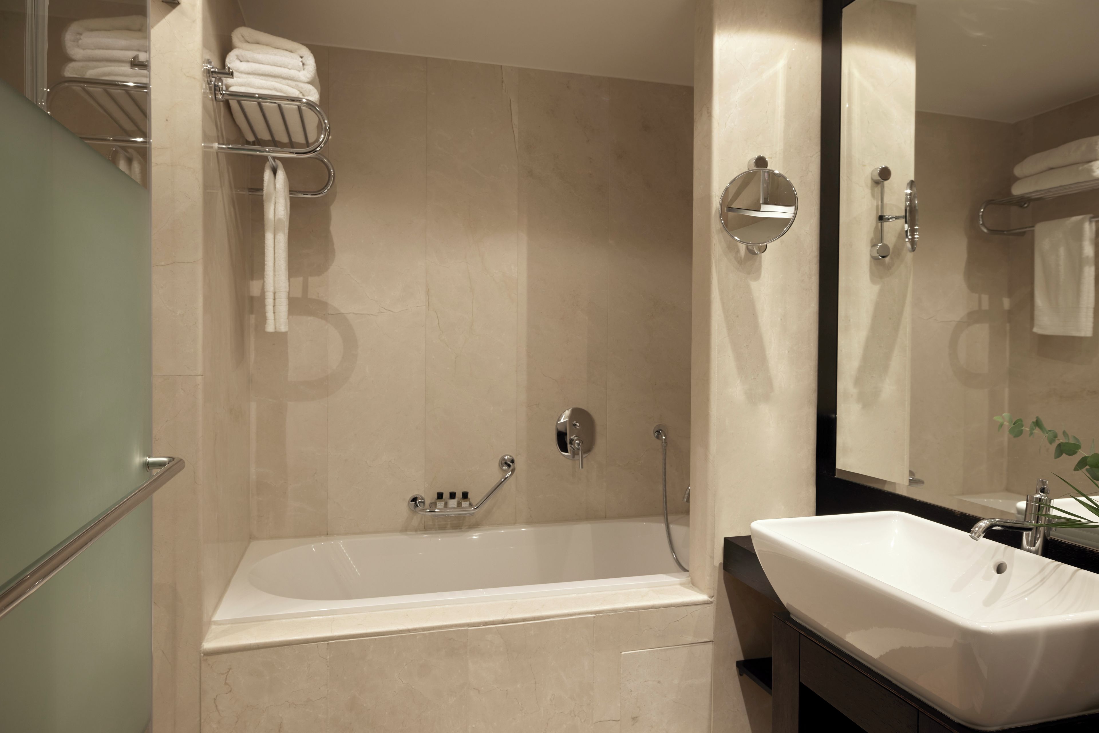 Un baño moderno con bañera, lavabo y espejo.