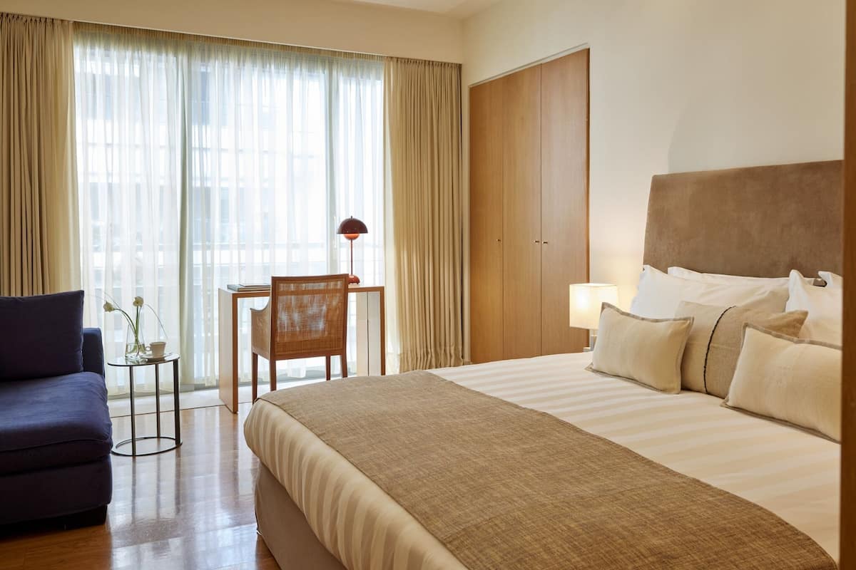 Een hotelkamer met een bed, bureau, stoel en een bank.