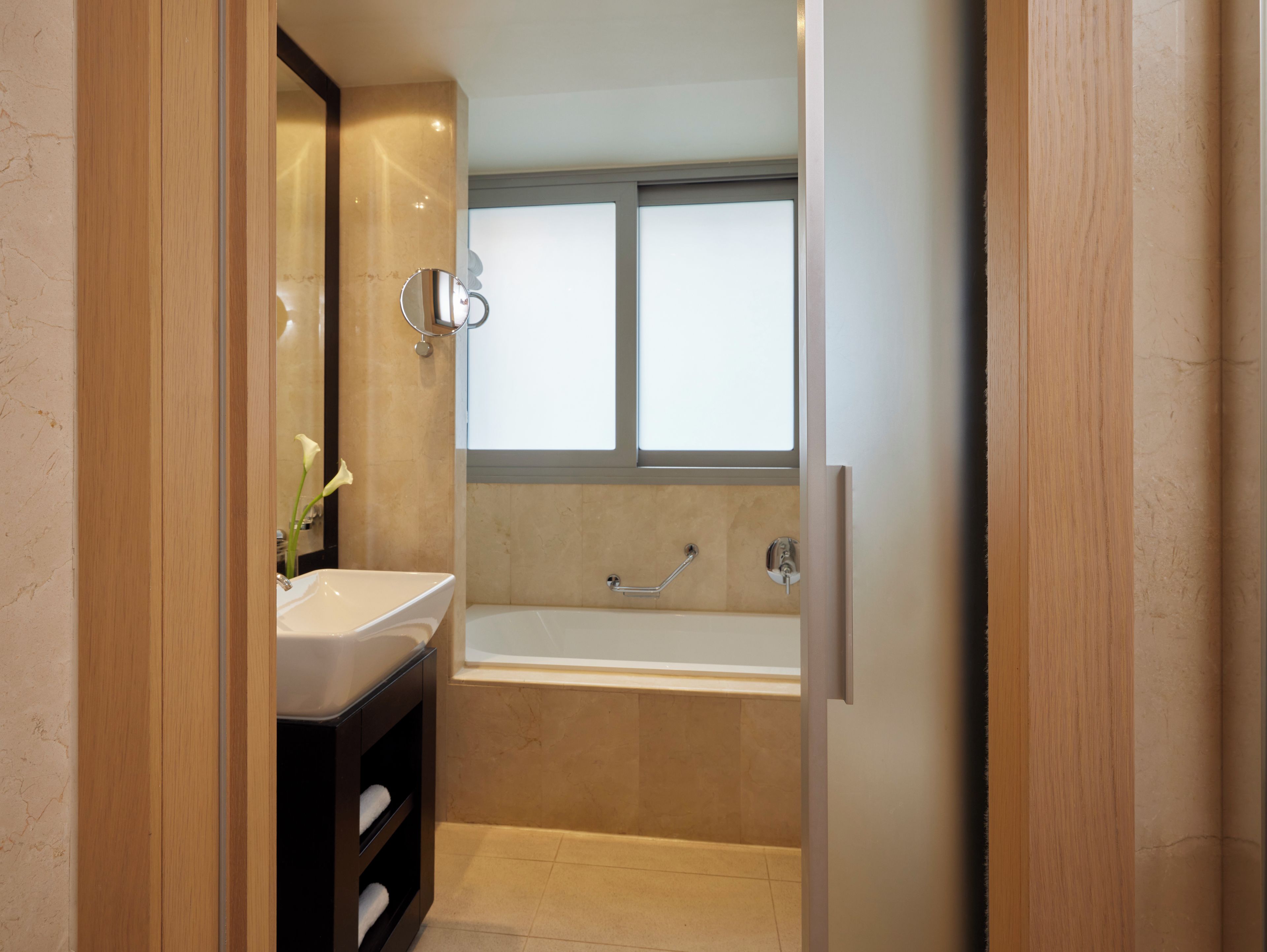 Un baño moderno con bañera, lavamanos y espejo.