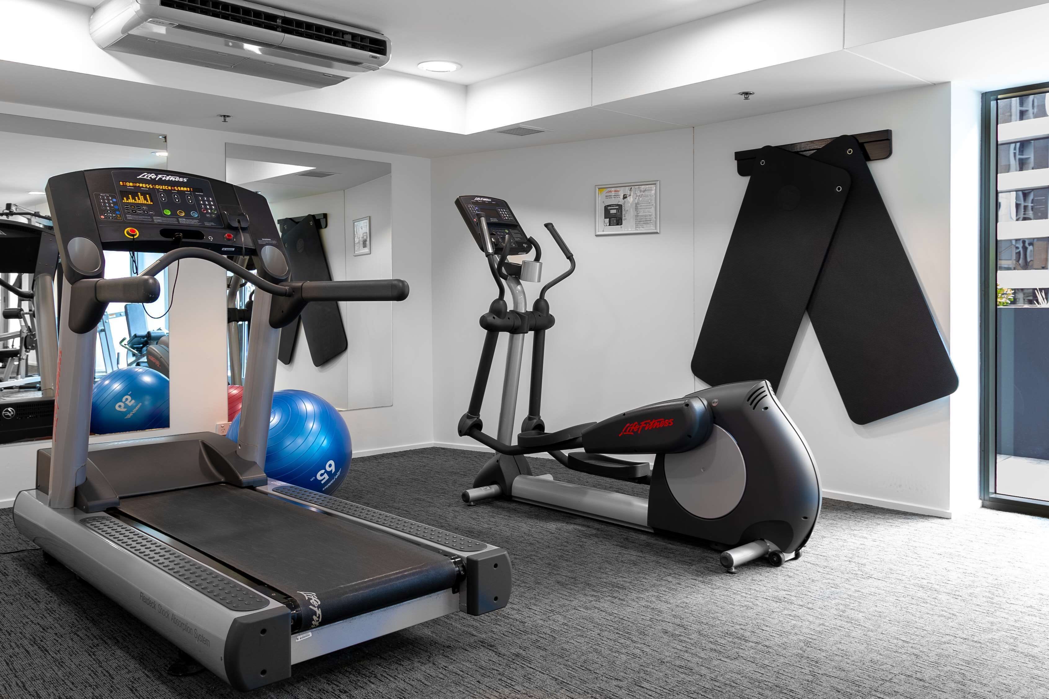 A gym with treadmills, an elliptical, and exercise balls.