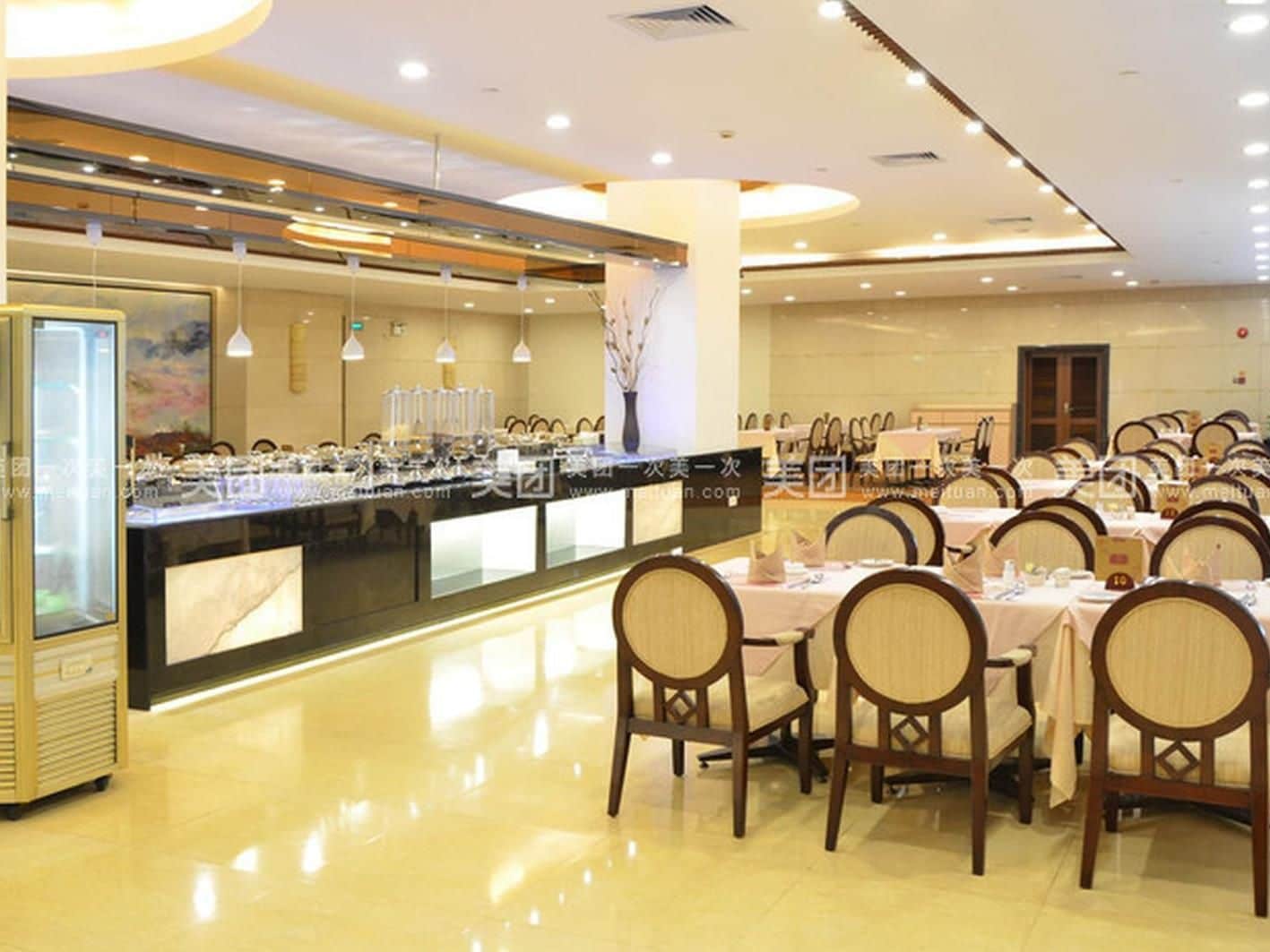 A dining area with round tables and chairs, a buffet counter, and a glass display case.