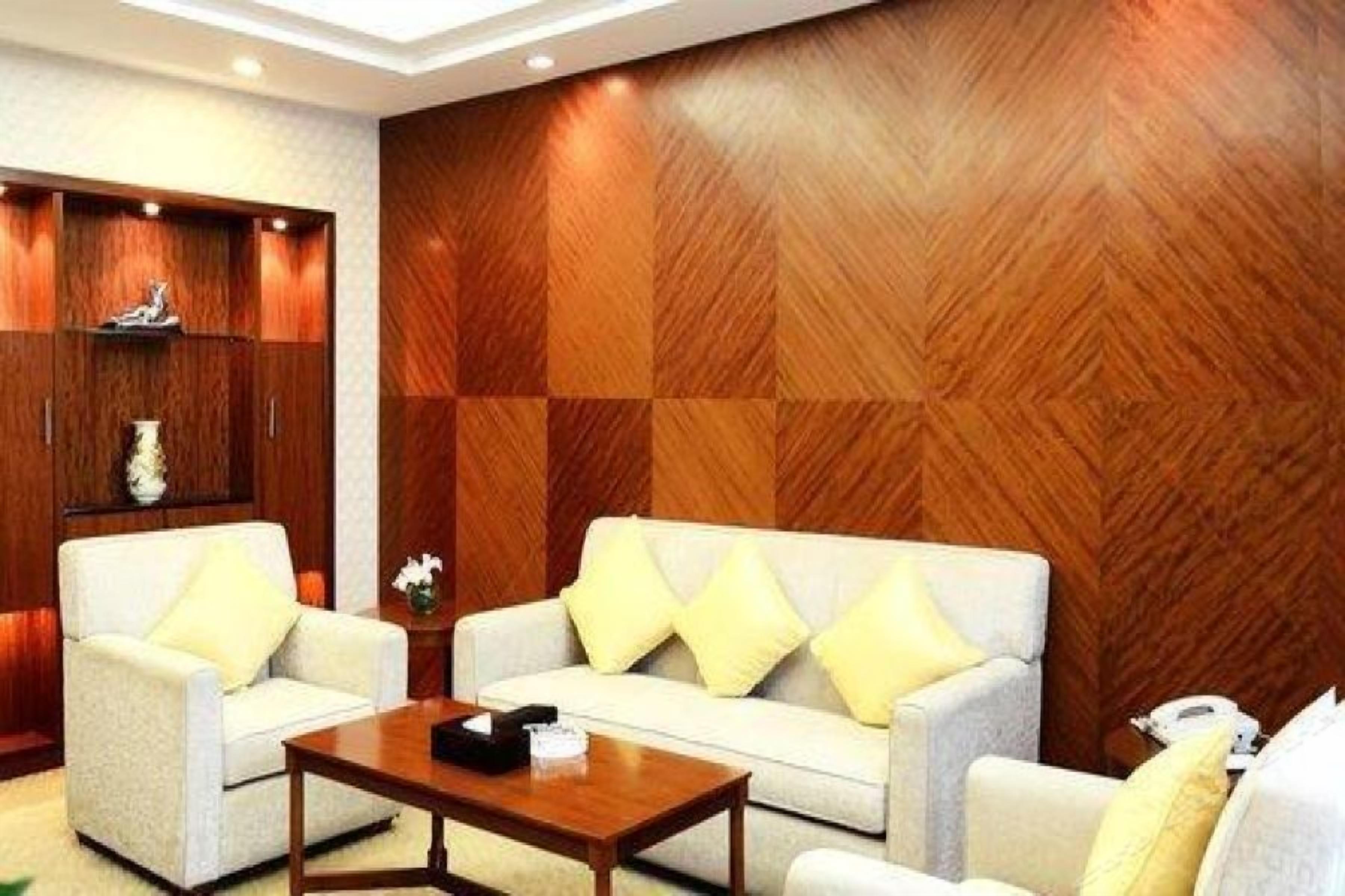 A room with a sofa set, a wooden cabinet, and a telephone on a side table.