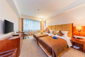 A hotel room with two beds, a desk, a television, and a window with curtains. - Chang an Hotel (Dongguan)