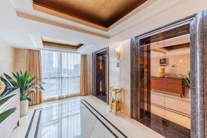A hotel lobby with a marble floor, a reception desk, a large window, and a plant. - Chang an Hotel (Dongguan)