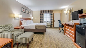 A hotel room with a bed, a sofa, a desk, a TV, and a chair. - Americas Best Value Inn Scarborough Portland (Scarborough)