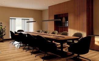Una sala de conferencias moderna con una mesa grande, varias sillas, una planta en maceta y un ventanal amplio.
