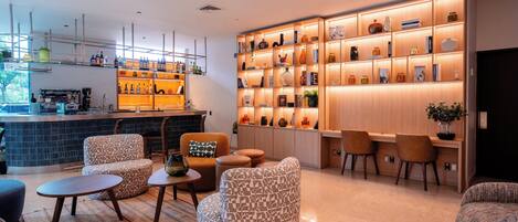 A modern bar area with seating and a bookshelf filled with books and decorative items.