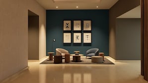 Un interior moderno con una pared de acento azul oscuro, obra de arte enmarcadas y muebles contemporáneos.
