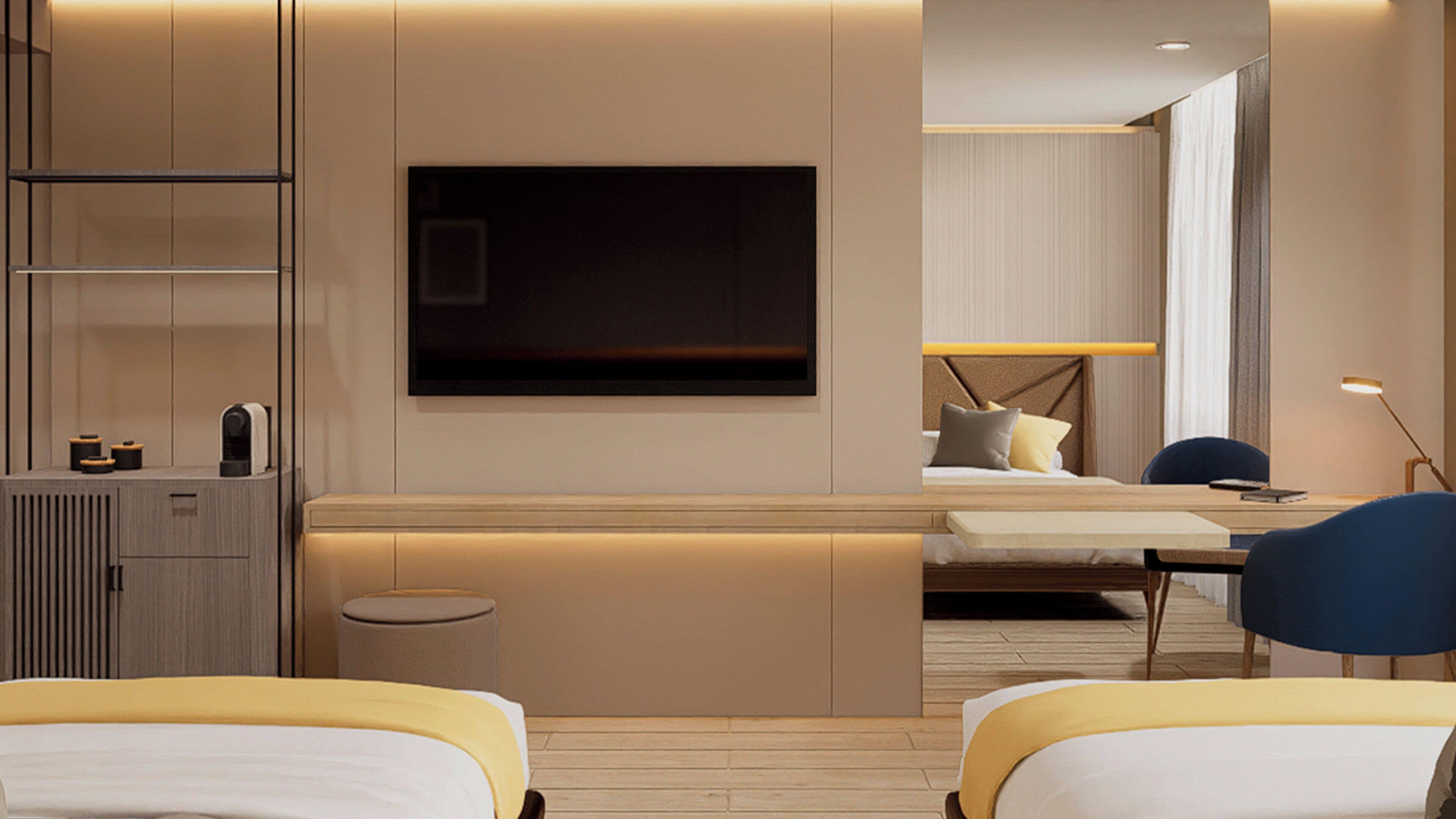 Una habitación de hotel moderna con un televisor de pantalla plana grande montado en la pared, una cama con cabecera, un escritorio con silla y un taburete pequeño y redondo.
