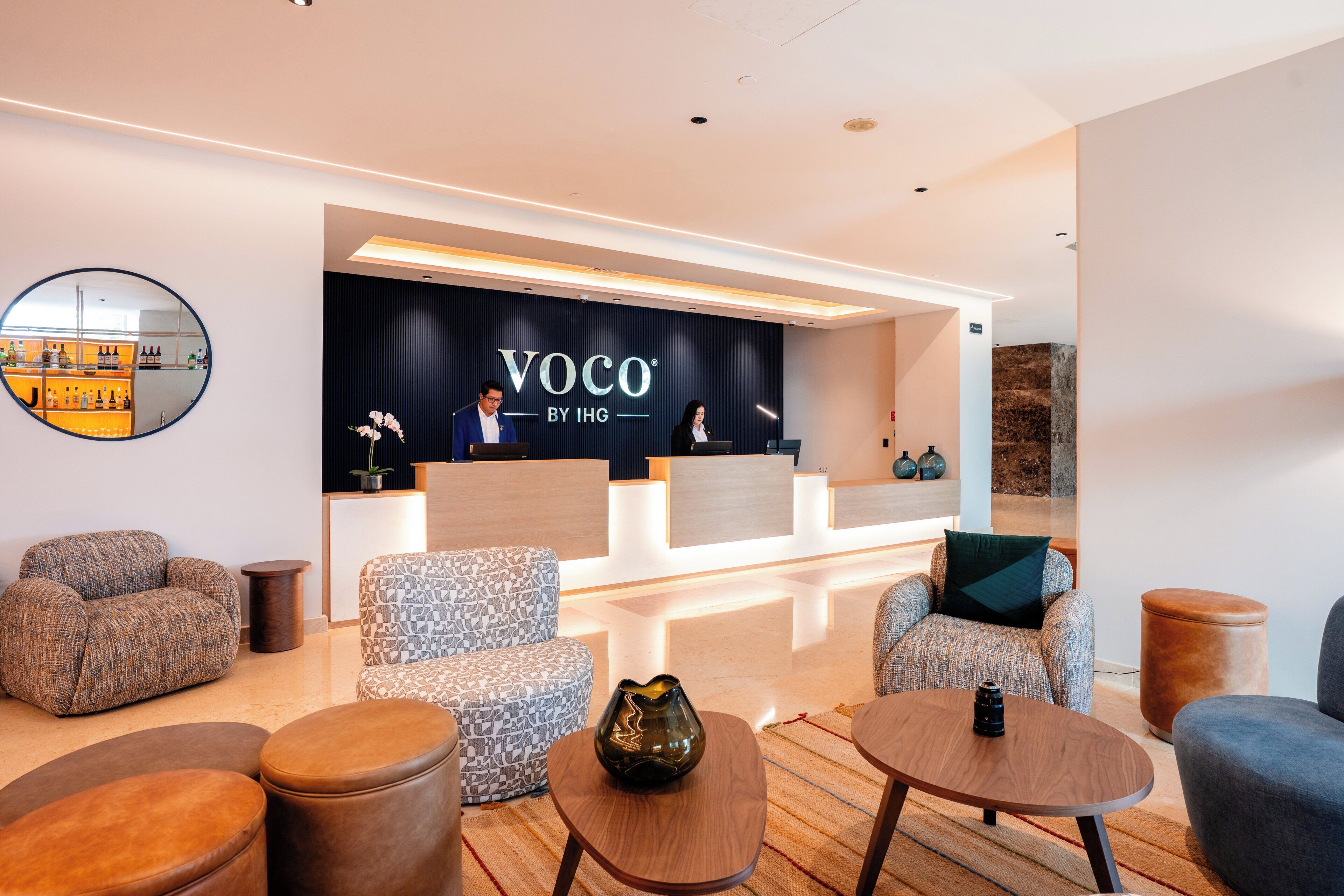 A modern reception area with a dark blue backdrop, a reception desk, and seating arrangements.