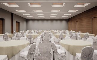 Un salón de conferencias con varias mesas y sillas, dispuestas en filas.