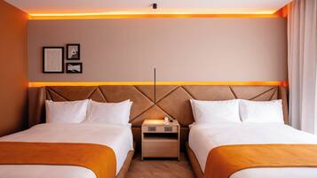 A hotel room with two beds, a nightstand, and a wall-mounted light fixture.