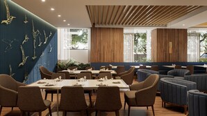 Un comedor moderno con una mesa larga, varias sillas y una pared azul decorada con un mural de aves.