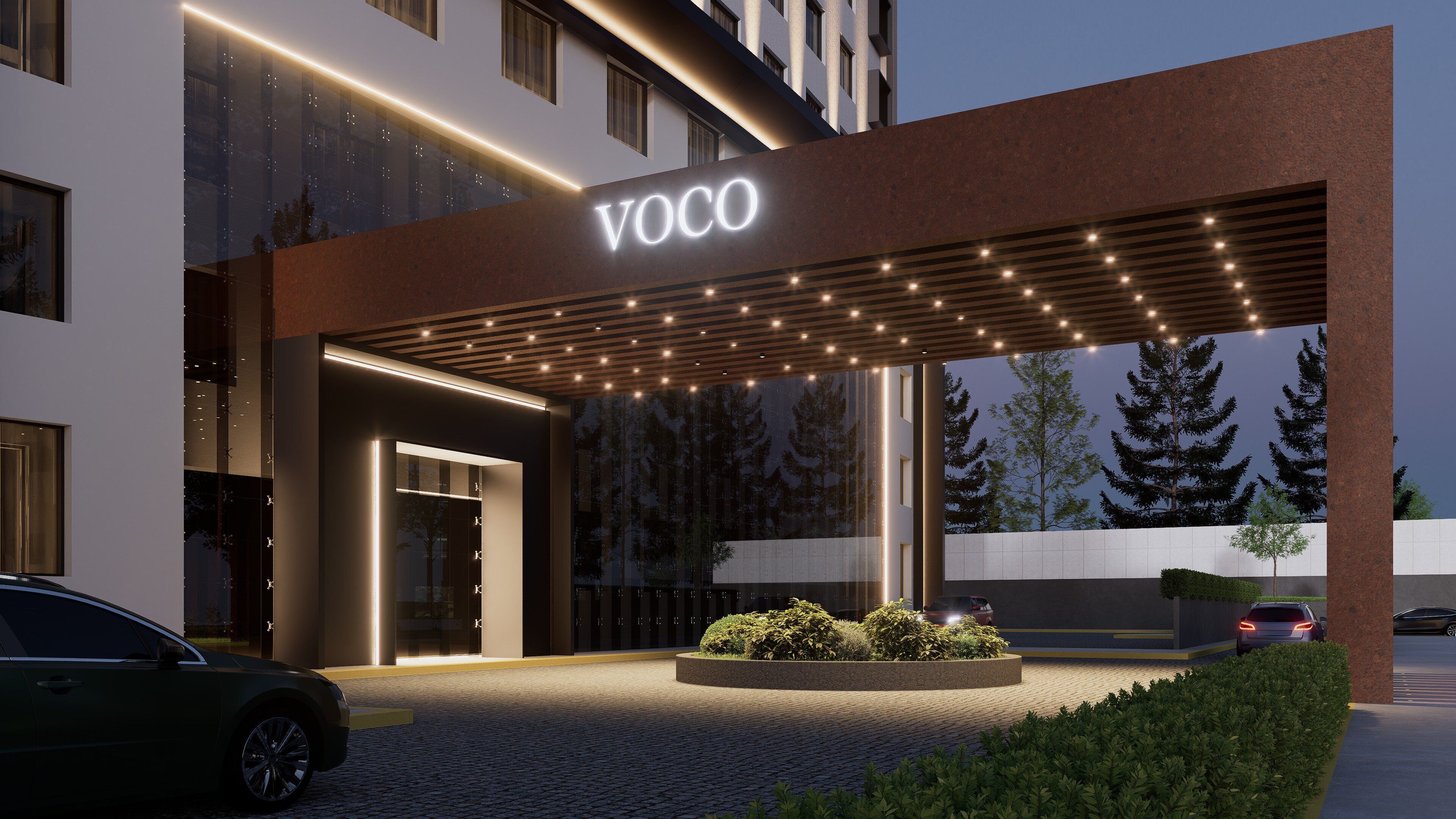 Entrada de hotel con diseño moderno, zona cubierta con iluminación y jardín ajardinado.