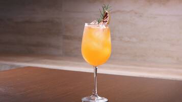 A clear glass with a beverage on a wooden surface.