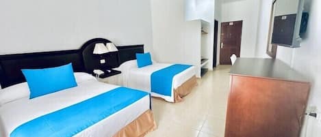 A hotel room with two beds, a desk, a mirror, and a wardrobe.