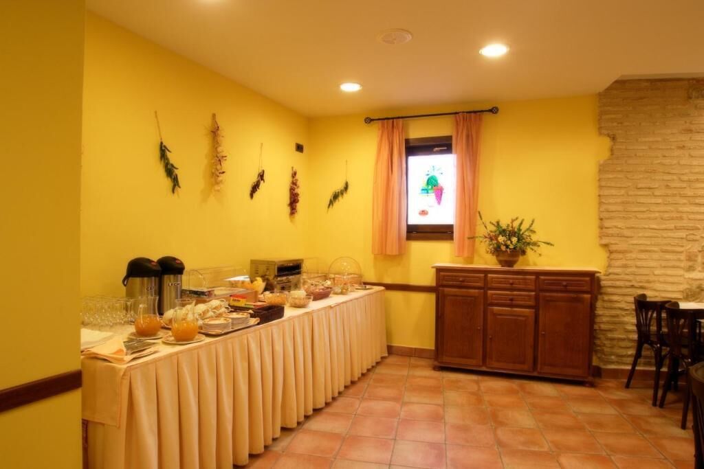 Comedor con mesa de buffet, pared de piedra y ventana con cortinas.