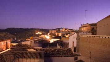 A view of a town with buildings and a hill in the background.