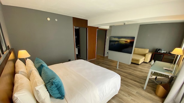 A modern hotel room with a large bed, a TV, a desk, and a sofa. - 474 Buenos Aires Hotel (Buenos Aires)