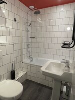 Ein Badezimmer mit Dusche, Toilette und Waschbecken.