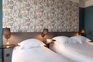 A hotel room with two beds, a patterned wall, and bedside lamps.