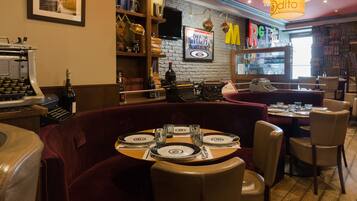 Un restaurante con pared de ladrillo, máquina de escribir antigua y zona de bar.