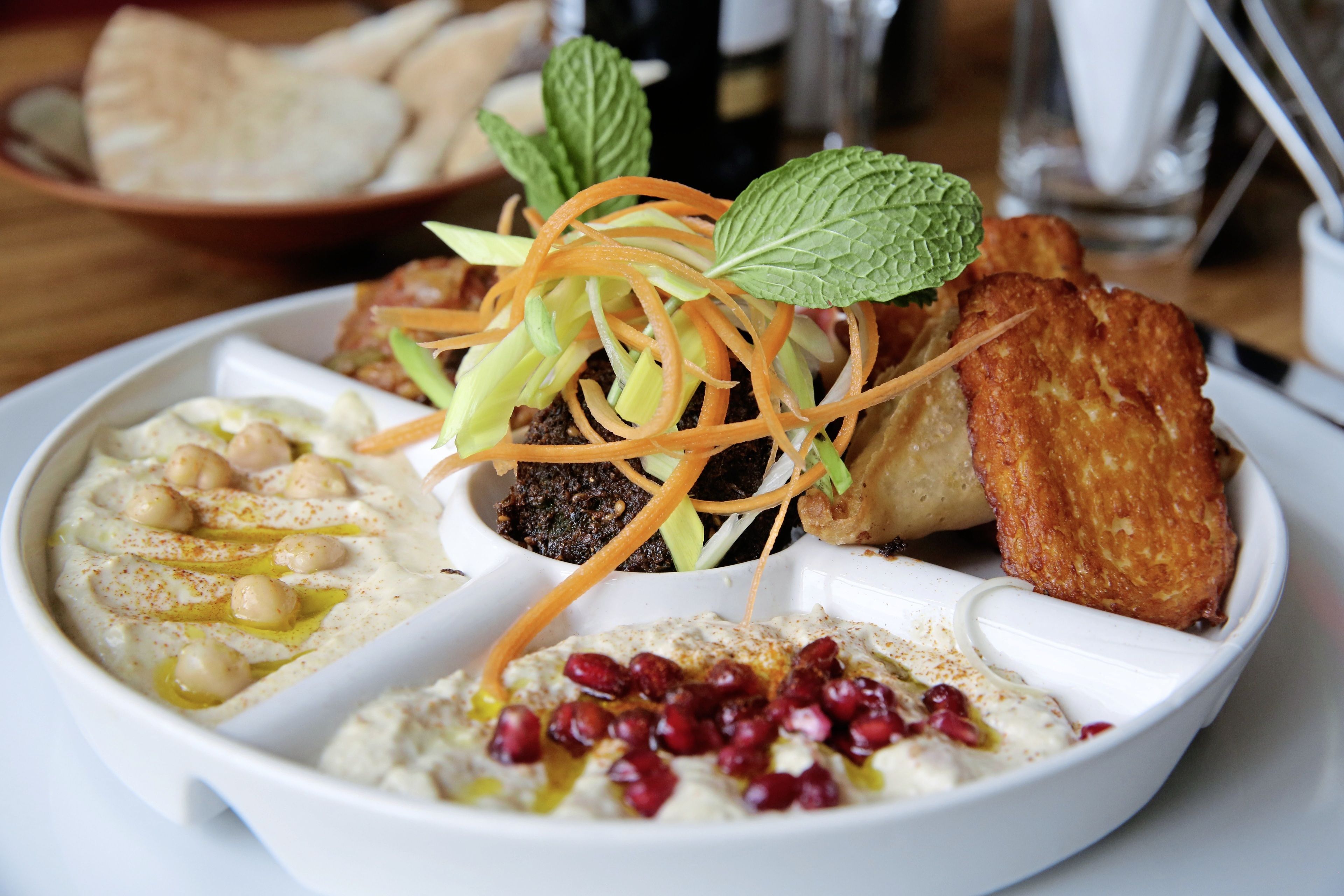 Un plato de comida con hummus, falafel y ensalada.