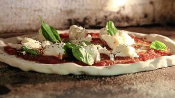 A pizza with cheese and basil on a wooden surface.