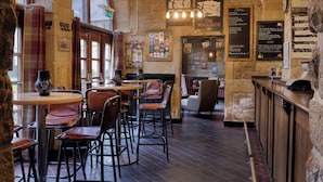 A cozy restaurant with stone walls, wooden tables, and leather chairs. - Weetwood Hall Conference Centre & Hotel (Leeds)