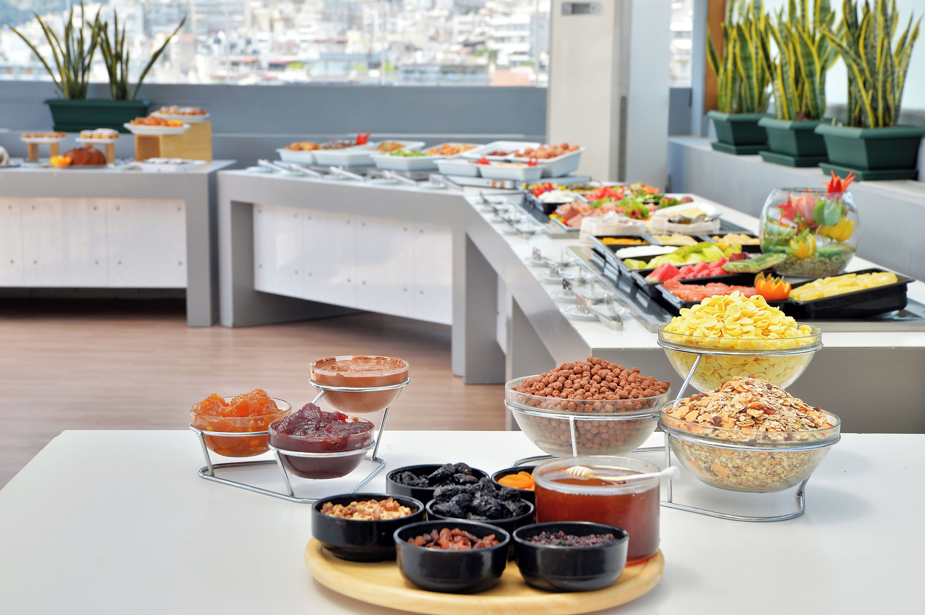 Ein Buffet mit verschiedenen Speisen und Blick auf die Stadt im Hintergrund.