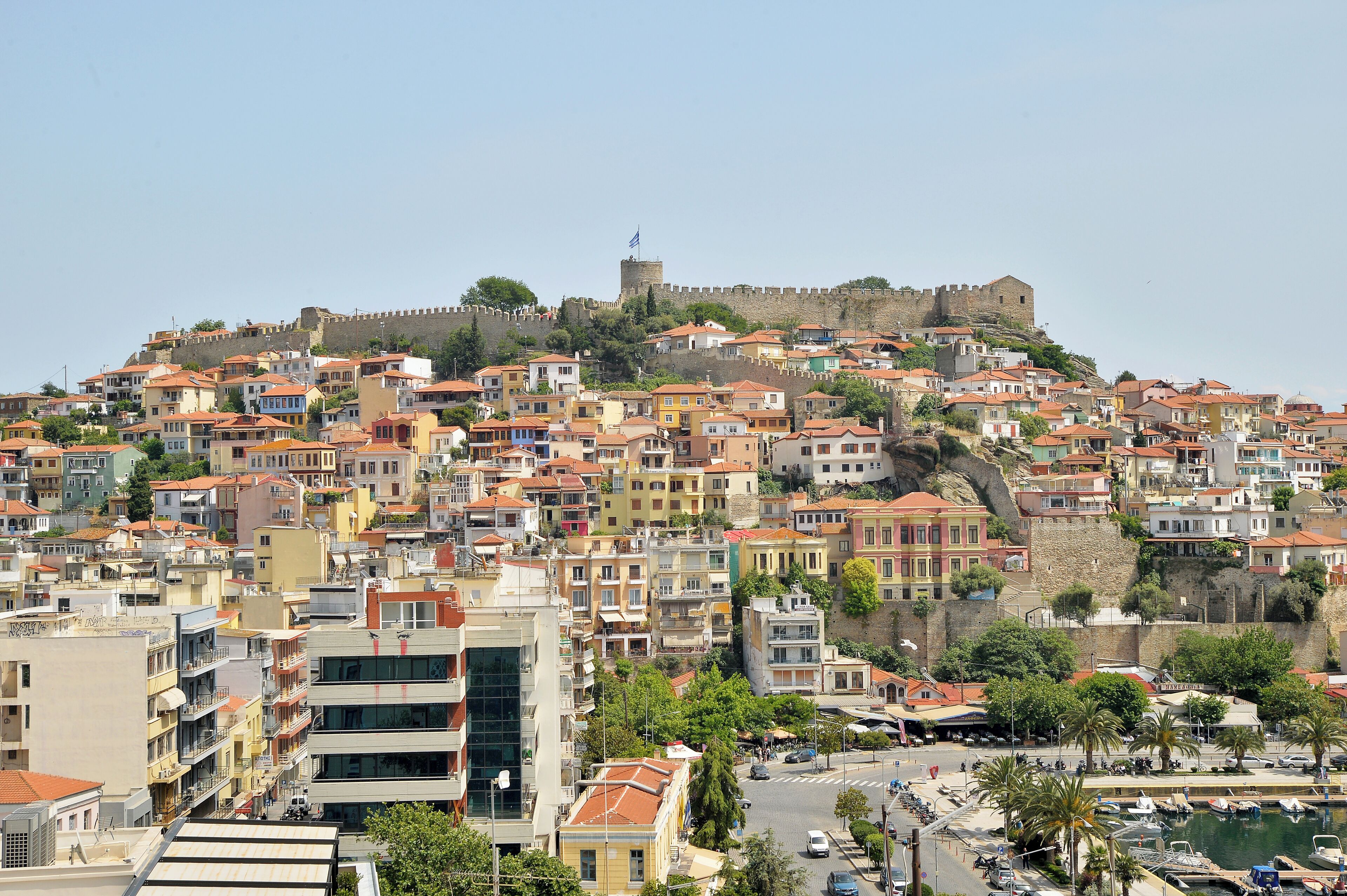 A coastal town with historic buildings and a prominent castle on a hill.