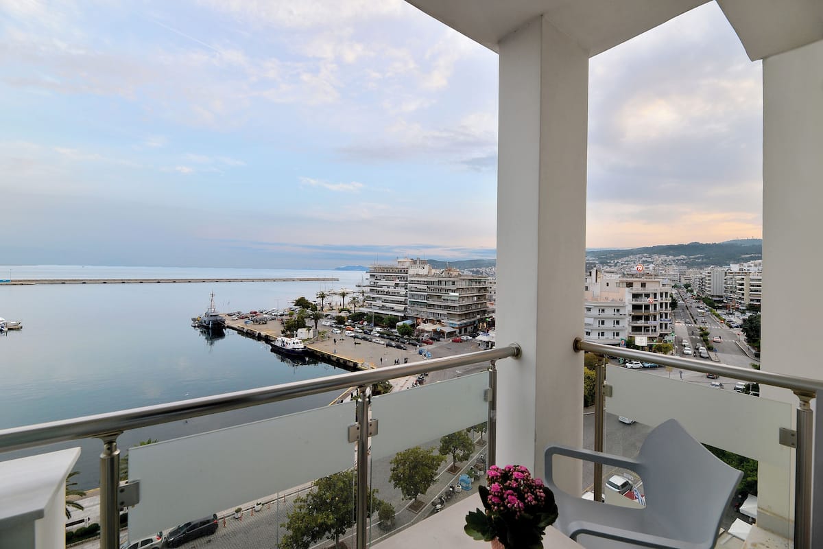A balcony with a view of a marina, buildings, and a cityscape.