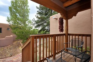 A wooden deck with a railing, a hanging dried plant, and a metal chair. - Casa Cuma Bed & Breakfast (Santa Fe)