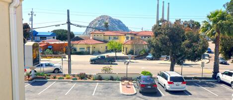 A parking lot with several cars and a building with a red roof in the background.