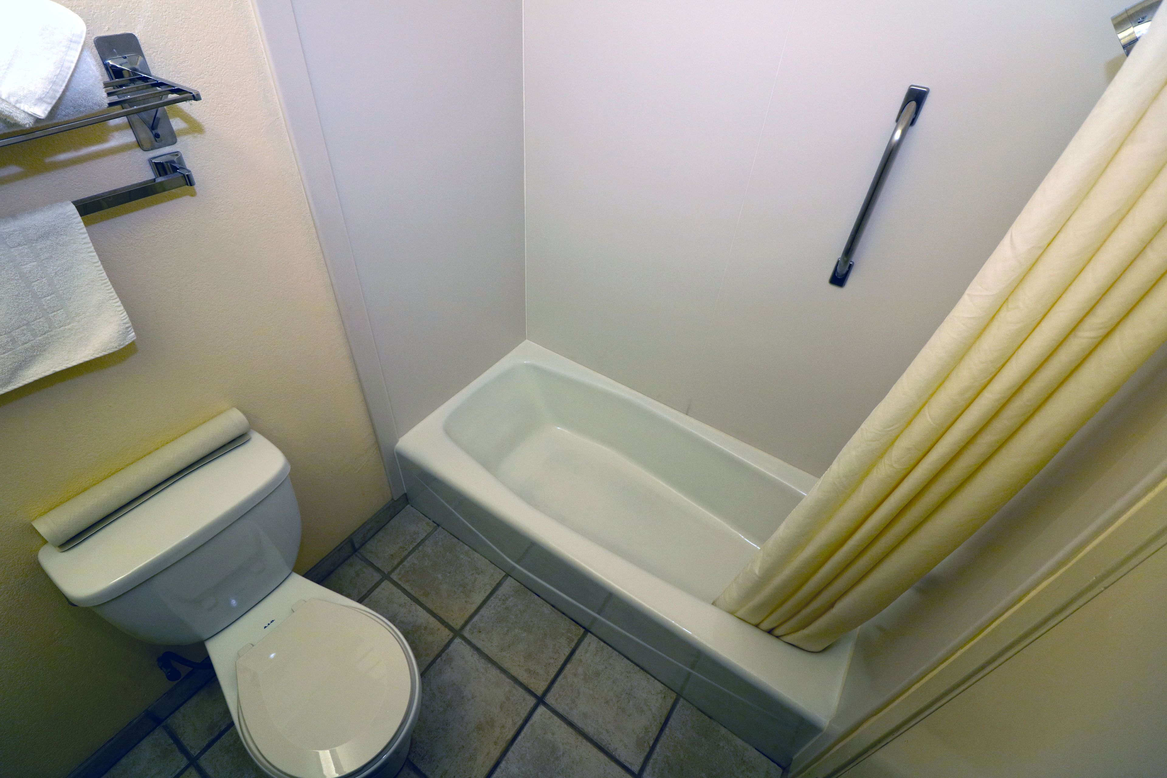 Ein kleines Badezimmer mit Toilette, einer Badewanne und einer Duschvorhang.
