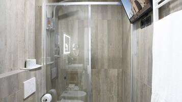 Une salle de bain moderne avec une douche à parois de verre, une baignoire sur pieds et des toilettes.