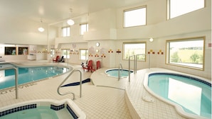 A large indoor swimming pool area with multiple pools and seating areas.