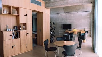 Een modern interieur met een houten kast, een ronde tafel en zwarte stoelen.