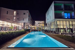 Una piscina al aire libre, sombrillas, tumbonas
