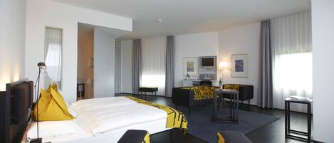Una habitación de hotel con cama, escritorio, sillón y sofá.