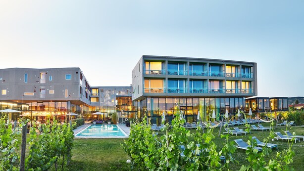 Un hôtel moderne doté d’une piscine, d’un espace extérieur aménagé et d’un jardin bien entretenu.