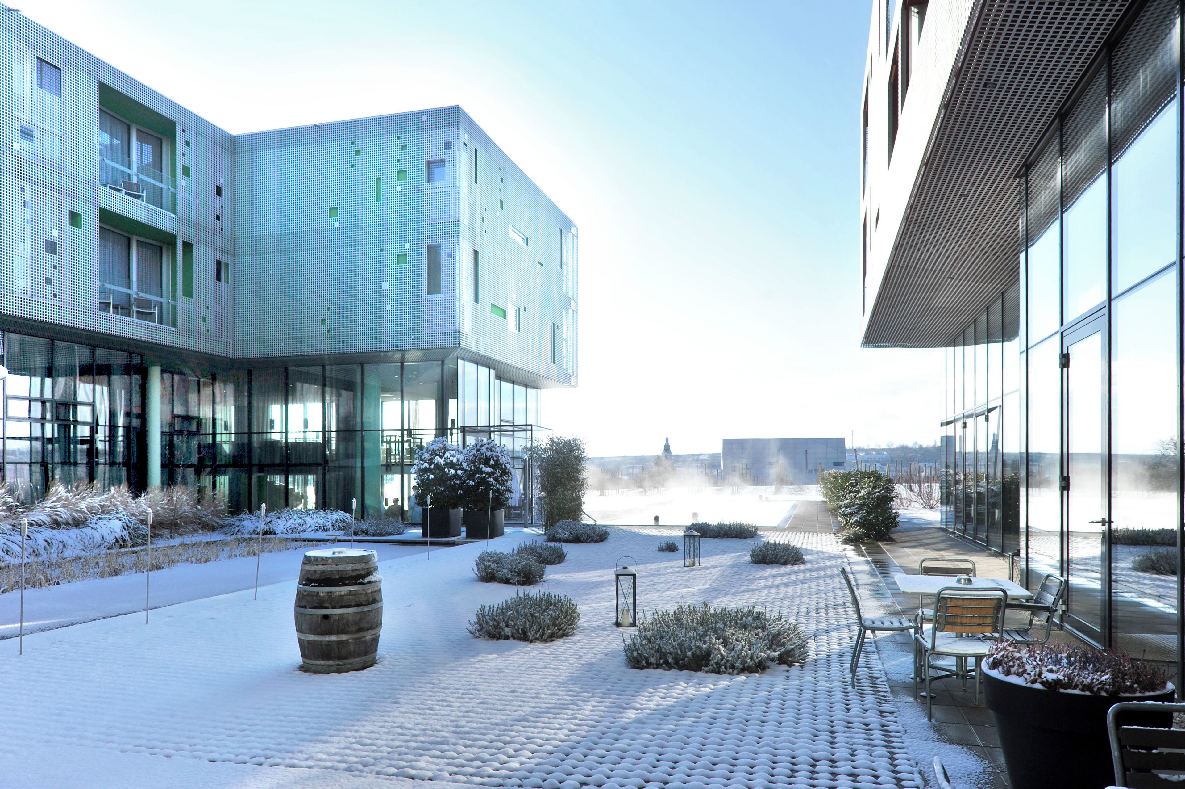 Een modern gebouw met grote ramen en een sneeuwbedekte binnentuin.