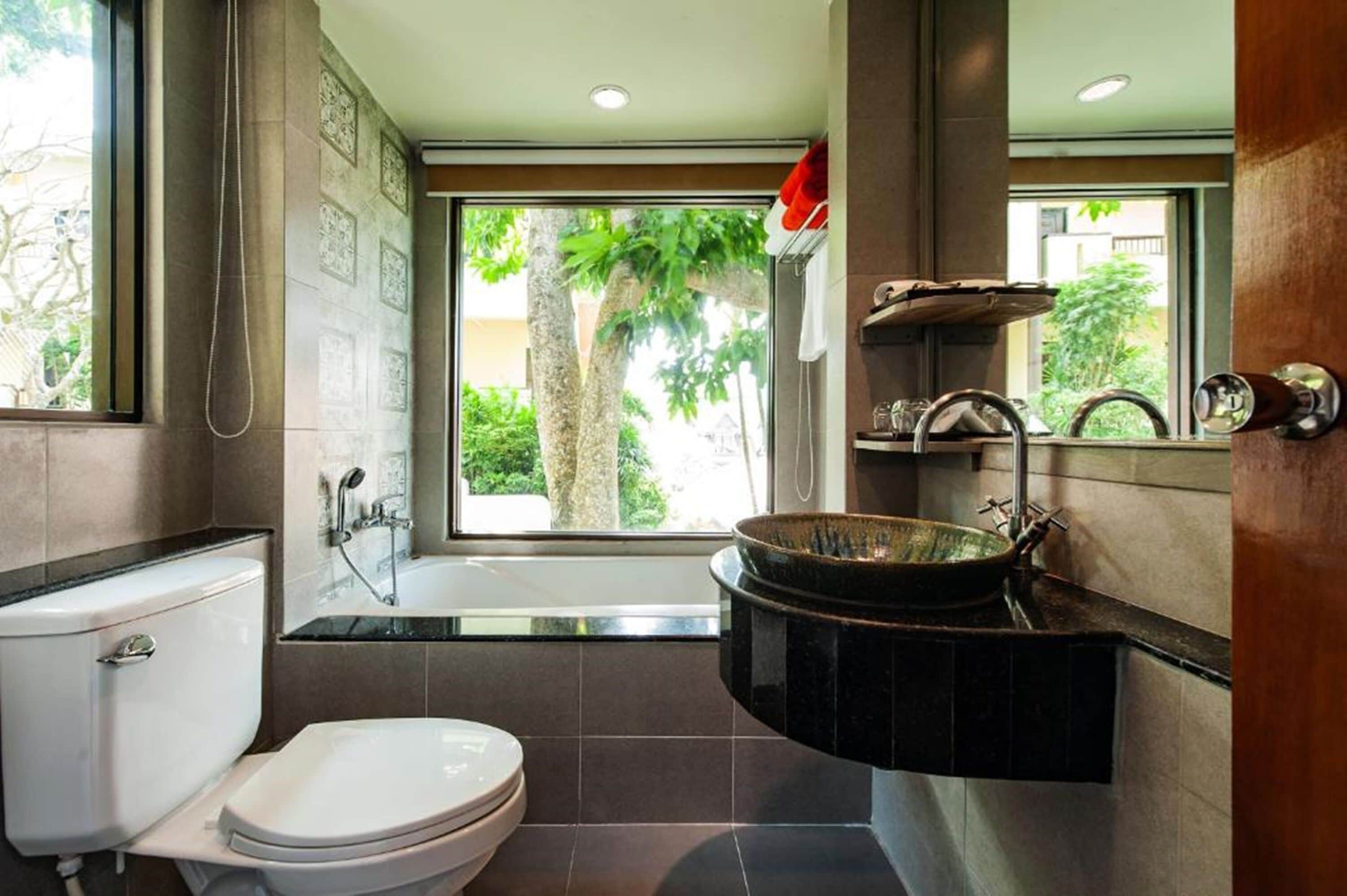 A modern bathroom with a toilet, sink, and bathtub.