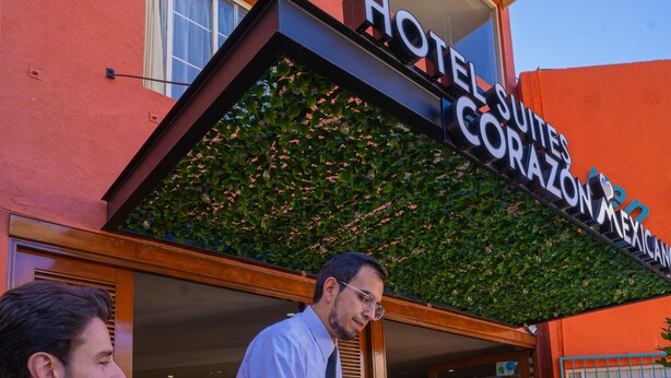 Esterno di un hotel con un cartello che riporta la scritta 'Hotel Suites Corazon Mexico'.