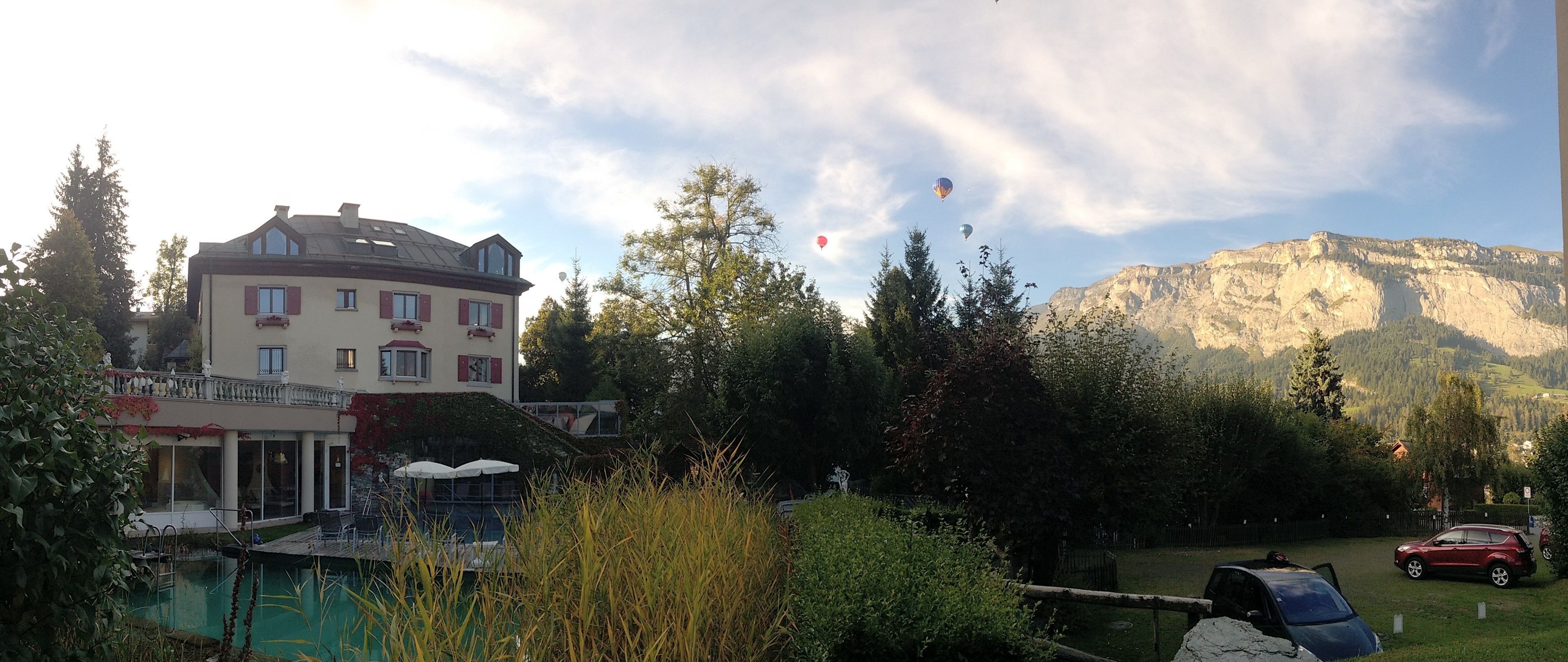 Un bâtiment doté d’un balcon, d’une piscine et surplombant un paysage montagneux.