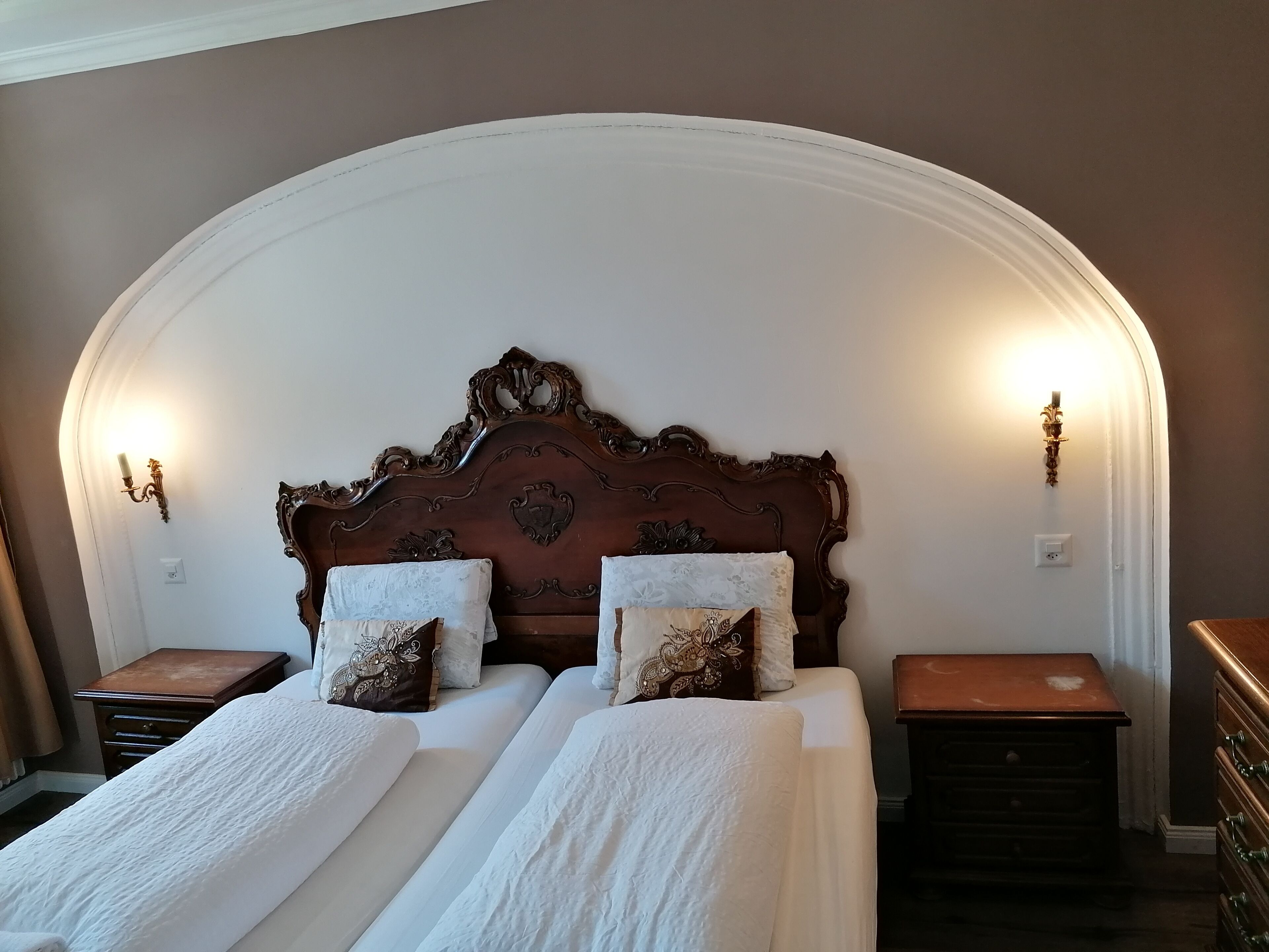 A bedroom with a large bed, two nightstands, and a dresser.