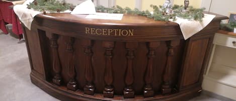 A reception desk with a sign reading "RECEPTION" and a nameplate.